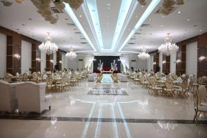 une salle de banquet avec des chaises, des tables et des lustres dans l'établissement Le Meridien Medina, à Médine