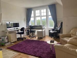 - un salon avec un canapé et un bureau avec un piano dans l'établissement Klassisk villa Ljungaverk Borrbodsvägen 1, à Ljungaverk
