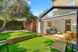 an extension to a house with a lawn at 3 Bedroom Mews Home - Clapham Common - Free Private Parking - Sleeps 5 - Newly Refurbished - Sweetpea & Pillow Properties in London
