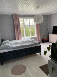 - une chambre avec un lit et une grande fenêtre dans l'établissement Klassisk villa Ljungaverk Borrbodsvägen 1, à Ljungaverk