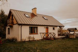 a small white house with a gambrel roof at Osmolicka Chatka in Ryki