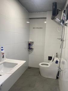 a white bathroom with a toilet and a sink at Homestay Highland Vân Hòa Phú Yên in Tuy Hoa