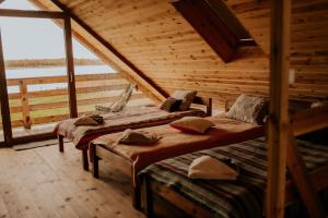 two beds in a log cabin with a large window at Osmolicka Chatka in Ryki