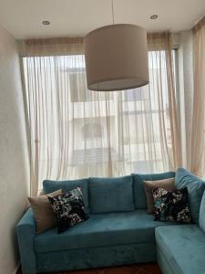 a blue couch in a living room with a large window at Luxury resident with pool in Cabo Negro