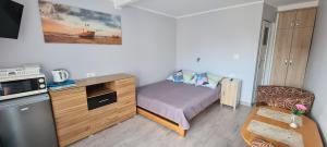 Moris 2 Pokoje Gościnne في ليبا: غرفة نوم صغيرة بها سرير وميكروويف