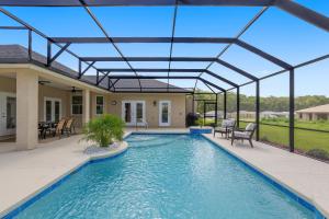 a swimming pool with a glass roof over a house at Villa Ilse: New Stylish Home With Private Pool in Inverness