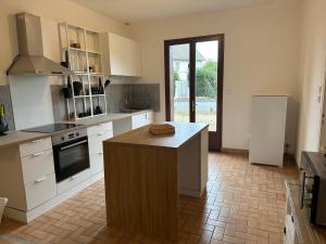 a kitchen with a island in the middle of it at Maison paisible, 15 min du Futuroscope & Arena. in Fontaine-le-Comte