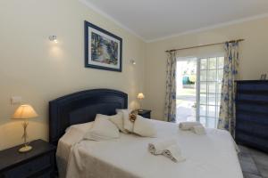 a bedroom with a bed with two slippers on it at Quinta do Rosal in Carvoeiro