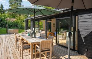 a wooden table with an umbrella on a deck at 3 Bedroom Amazing Home In Silkeborg in Silkeborg