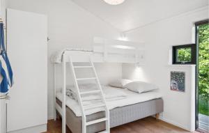 3 Bedroom Awesome Home In Silkeborg في سيلكبورج: سرير بطابقين أبيض في غرفة بيضاء مع سلم