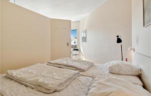 two beds in a bedroom with white walls at Fan Bad, Lejl, 109 in Fanø