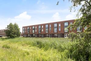 een appartementencomplex met een grasveld ervoor bij Residence Sanne in Breda