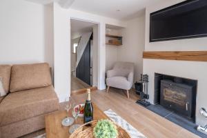 ein Wohnzimmer mit Couch und Kamin in der Unterkunft Avocet Cottage in Aldeburgh