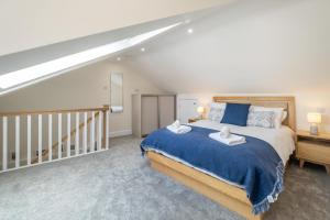 ein Schlafzimmer mit großem Bett und Treppe in der Unterkunft Avocet Cottage in Aldeburgh