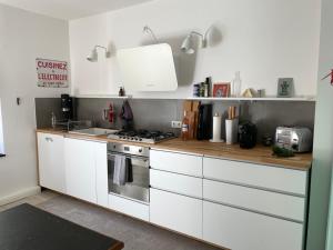 eine Küche mit weißen Schränken und einem Herd in der Unterkunft Haus mit Türmchen in Solingen