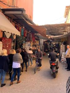 un gruppo di persone che camminano per un mercato di Riad En exclusivité a 99 euros avec 5 chambres a Marrakech