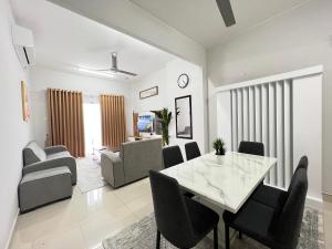 a dining room and living room with a table and chairs at Terengganu Dreamscapes at Icon Residence, Spacious with Nature View in Kuala Terengganu