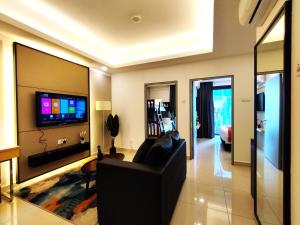 sala de estar con sofá negro y TV de pantalla plana en TopGenting SkyForestColdSty2R1B7Pax @GrdIonDelmn, en Genting Highlands