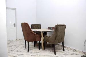 uma mesa de jantar com duas cadeiras e uma mesa em CIS Apartments em Abuja