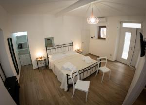 - une chambre avec un grand lit blanc et deux chaises dans l'établissement B&B Il vicoletto, à Pratola Peligna