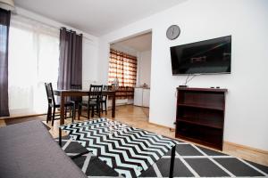 sala de estar con mesa y TV en Green Kabaty Apartment 2, en Varsovia