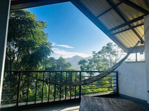 a room with a balcony with a view of the mountains at Ella Festoon in Ella