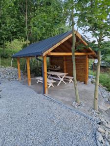 einem Holzpavillon mit einem Picknicktisch und Bäumen in der Unterkunft Nad Strumieniem in Peterswaldau
