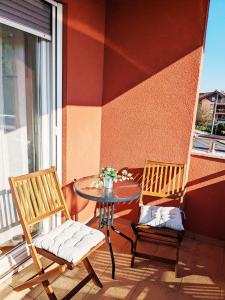 Velika MlakaにあるDoMa-Lu apartment with free parkingのテーブルと椅子2脚、バルコニー(テーブル、窓付)
