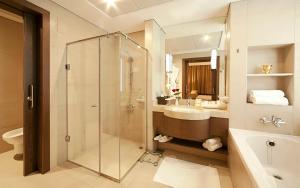 a bathroom with a shower, sink, and toilet at Oaks Liwa Executive Suites in Abu Dhabi