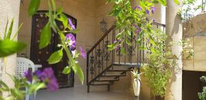 La Colline de Chott Meriem appartements في سوسة: ممر به درج حلزوني وزهور أرجوانية