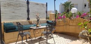 een patio met een tafel en stoelen en een bank bij La Colline de Chott Meriem appartements in Sousse