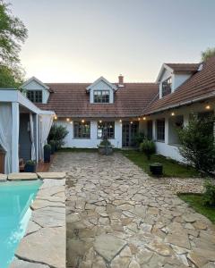 uma casa com um pátio de pedra e uma piscina em 44 George House - Pool, Jacuzzi, Sauna, View em Tilaj