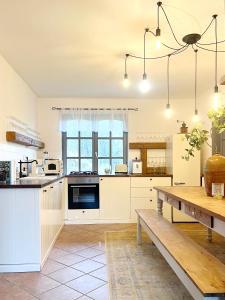 cocina con armarios blancos y mesa de madera en 44 George House - Pool, Jacuzzi, Sauna, View, en Tilaj