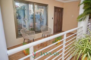 balcón con 2 sillas y ventana en JANNAH VILLAS - GHANA, en Adentan