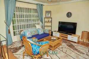 a living room with a couch and a television at JANNAH VILLAS - GHANA in Adentan