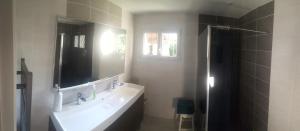 a bathroom with a sink and a mirror at VILLA LA PAVOTTE 4* 11 PERSONNES.PISCINE CHAUFFEE.JACCUZY OPTION. in Mimizan