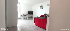 ein Wohnzimmer mit einem roten Sofa und einem TV in der Unterkunft Charmant studio au rez de chaussée. in Denain