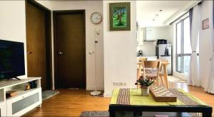 uma sala de estar com uma mesa e um relógio na parede em Modern and Comfortable Staycation - Unit 3718 Novotel Tower em Manilla