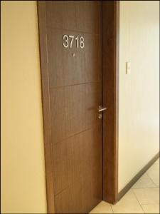 eine Holztür mit Zahlen auf einem Zimmer in der Unterkunft Modern and Comfortable Staycation - Unit 3718 Novotel Tower in Manila