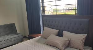 a bedroom with a bed and a window and a chair at Islamabad 430 B&B Hotel in Islamabad