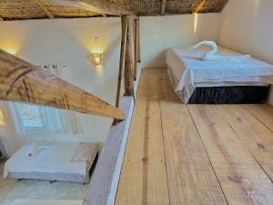 Pokój z 2 łóżkami i drewnianą podłogą w obiekcie Pousada Casa Eco Paracuru w mieście Paracuru