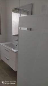 een witte badkamer met een wastafel en een spiegel bij Casa Tia Pilar in Algodonales