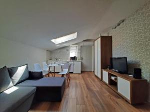 a living room with a couch and a table with a tv at Apartments Center Opatija Ziric in Opatija