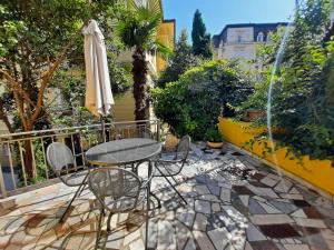 a patio with a table and chairs and an umbrella at Apartments Center Opatija Ziric in Opatija