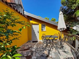 a yellow house with a table and an umbrella at Apartments Center Opatija Ziric in Opatija