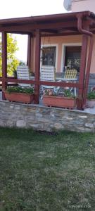 a porch with white benches and plants on a building at Mavridis House in Eleftheroúpolis