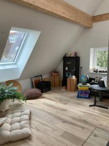 Neues Penthouse-Loft mit KONUSKarte für gratis ÖPNV في Ehrenkirchen: غرفة مع العلية مع نافذة وأرضية خشبية