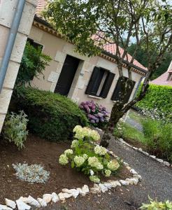 un jardín con flores frente a una casa en Maison Hyacinthe of Tournesol geniet in luxe, en Castelnaud La Chapelle