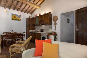 ein Wohnzimmer mit einem Sofa und einer Küche in der Unterkunft CASA IL MANDORLO NEL CHIANTI in Castellina in Chianti