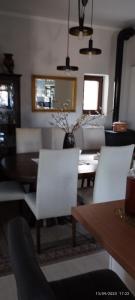 a dining room with white chairs and a table at Mavridis House in Eleftheroúpolis
